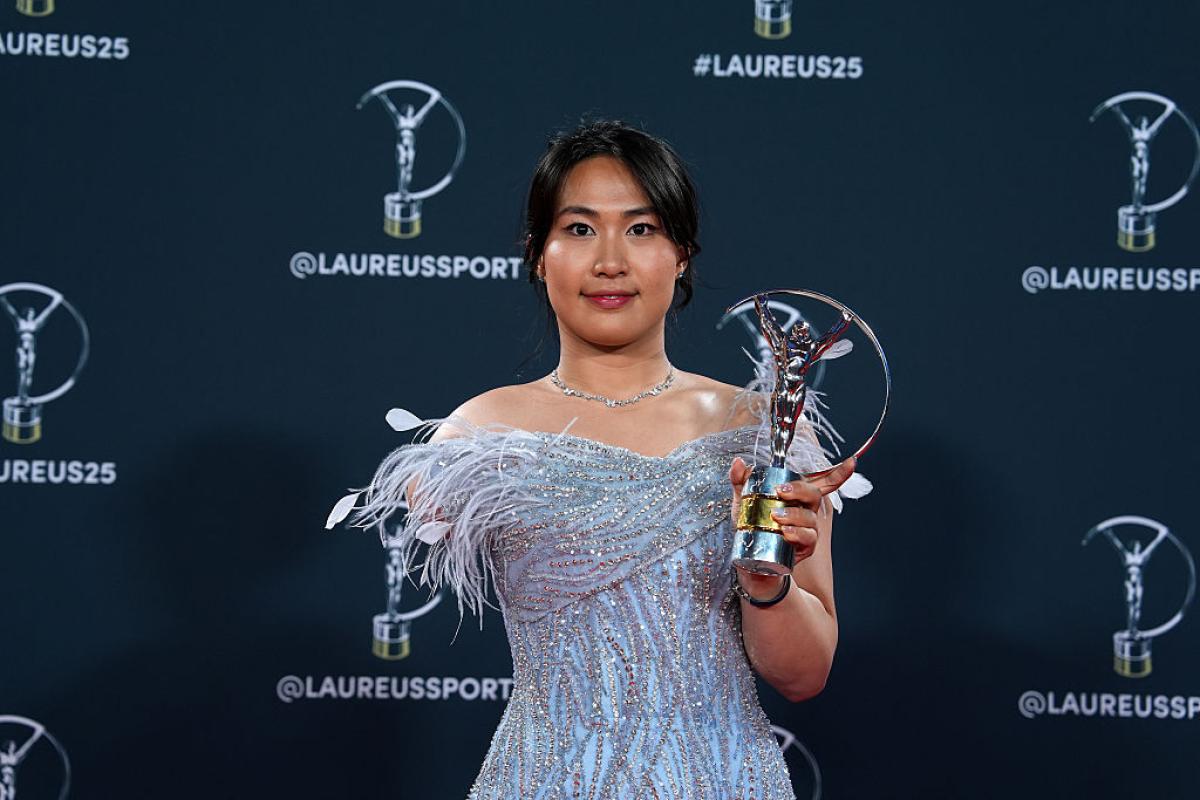 Yuyan Jiang smiles for a photo while holding the Laureus trophy with her left hand